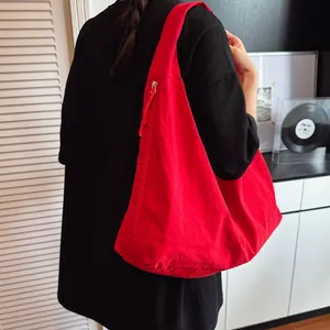 Large red canvas tote bag with minimalist design and shoulder strap for casual daily use