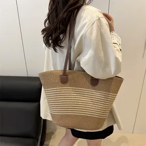 Summer woven straw tote bag with striped pattern and leather handles for beach or commute