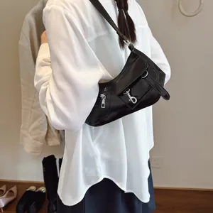 Retro black glossy underarm bag for women with metallic buckle shown on a model