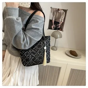 Fashionable black tote bag with white geometric floral embroidery and silk tassel detail