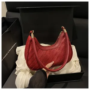 Dettaglio della borsa hobo intrecciata rosso scuro con finiture dorate in regalo