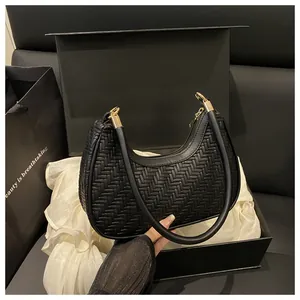 Dettaglio borsa hobo intrecciata nera con finiture dorate e set confezione regalo luxury