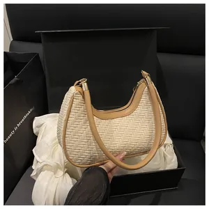 Dettaglio della borsa intrecciata con bordo in pelle e cerniera dorata elegante
