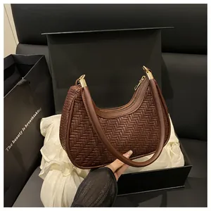 Dettaglio borsa hobo intrecciata marrone scuro con trama fine e finiture in metallo oro