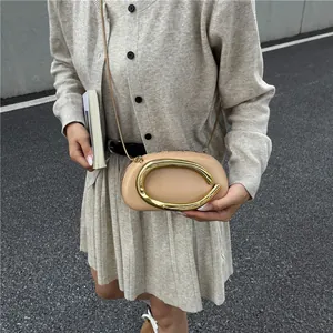 Sac oreiller beige minimaliste avec anneau doré et fine bandoulière sur mannequin