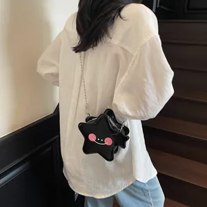 Chic black star-shaped crossbody bag with smile detail and silver chain on model