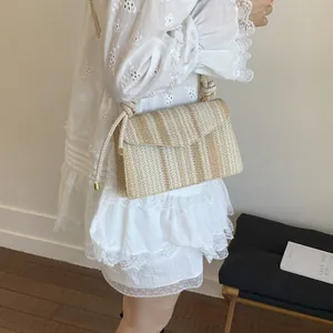 Striped woven straw crossbody bag with beige rope strap for summer vacation style