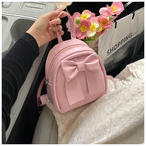 Detailed macro view of a pink bow mini backpack in soft PU leather with metal zipper detail