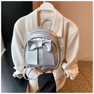 Macro detail of silver metallic bow backpack with polished PU leather and zipper closure