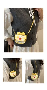 Détail du mini sac bandoulière à carreaux jaunes avec motif de chien et nœud décoratif