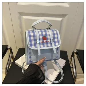 Detail of light blue plaid backpack with embroidered apple and adjustable straps