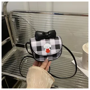 Détail du sac bandoulière à carreaux avec nœud en cuir noir et imprimé chiot mignon