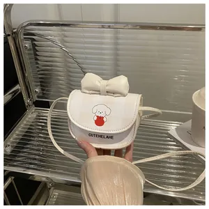 Gros plan du mini sac à bandoulière crème avec nœud et motif de chiot mignon