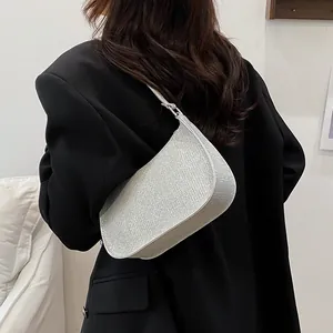 Elegant silver glitter crescent shoulder bag for women styled with a black blazer