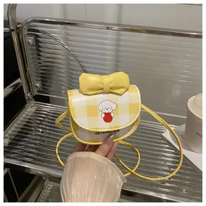 Détail du mini sac bandoulière à carreaux jaunes avec motif chien mignon et nœud