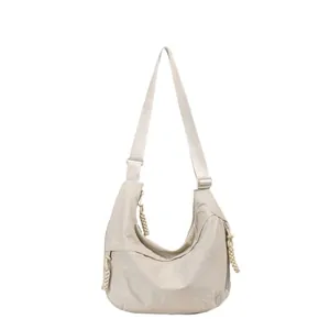 Minimalist beige crinkled nylon crescent crossbody bag with adjustable wide shoulder strap