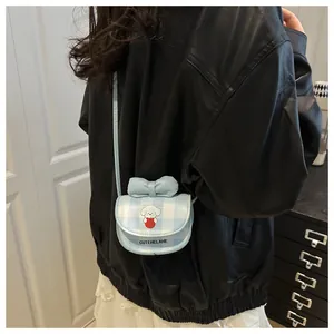Vue arrière d'un mini sac bandoulière bleu clair avec chien de dessin animé sur veste noire