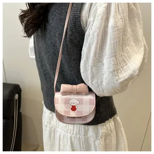 Détail du sac bandoulière à carreaux roses avec chiot mignon et nœud en cuir