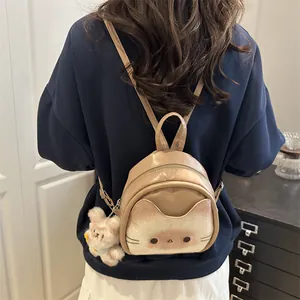 Mini sac à dos chat beige mignon avec pendentif en peluche porté par un mannequin