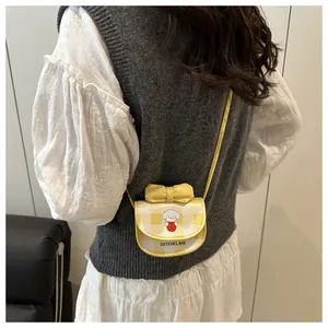 Détail du mini sac bandoulière jaune à carreaux avec nœud et motif de chien mignon