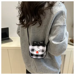 Détail du mini sac bandoulière à carreaux avec chien de dessin animé et sangle noire
