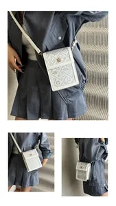 Détail d'un mini sac seau beige avec motifs géométriques gris et fermoir fleur dorée