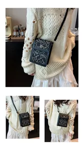 Détail du sac seau vintage avec motif jacquard floral et fermoir trèfle doré élégant