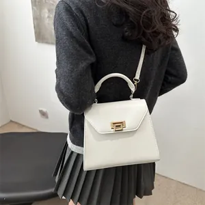 Elegant white leather crossbody handbag with gold hardware shown on a female model