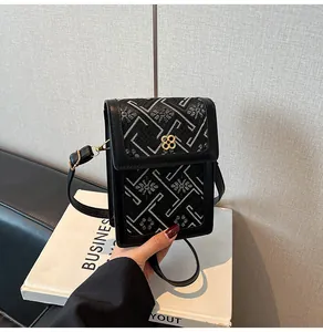 Détail du mini sac seau noir avec broderie et boucle trèfle dorée élégante
