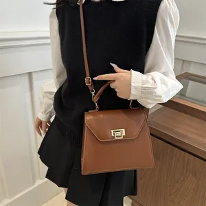 Elegant vintage brown leather handbag with gold clasp and adjustable shoulder strap