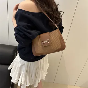 Vintage brown leather saddle bag with gold bow detail, styled on shoulder with summer outfit