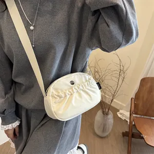Minimalist beige pleated backpack with broad canvas strap and brand logo for casual travel