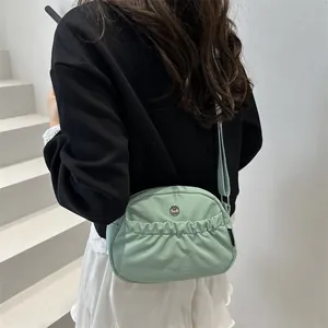 Light green pleated casual backpack with adjustable straps on minimalist model