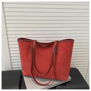 Detail of burgundy suede tote bag featuring brown leather trim and FANYISSA brand name