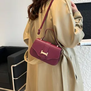 Borsa a spalla in pelle bordeaux con fibbia dorata mostrata indossata da modella