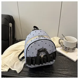 Détail du mini sac à dos rayé avec motifs de cœurs et nœud noir élégant décoratif