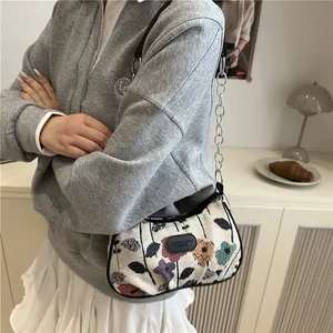 Vintage floral embroidery canvas hobo bag with chain strap shown on model's shoulder
