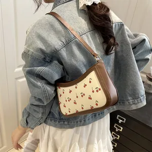 Borsa a mezzaluna con stampa ciliegie, finiture in pelle marrone e catena elegante
