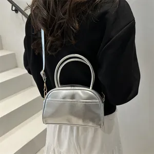 Minimalist silver metallic pillow bag for women featuring a sleek crescent design