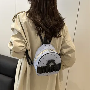 Mini sac à dos rayé bleu clair avec coeurs noirs et noeud porté par un mannequin