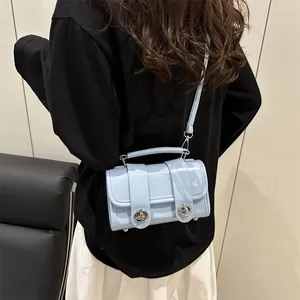 Bolso cuadrado azul claro brillante con cierre giratorio plateado y asa superior de mujer