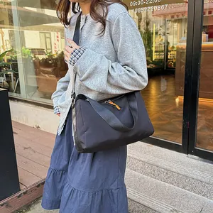 Sporty black nylon crossbody bag for travel and fitness shown on a female model