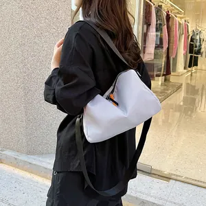 Minimalist lavender crossbody bag with adjustable black strap and orange zipper detail