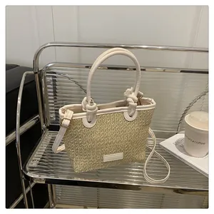 Detail showing woven straw texture and white faux leather handle with elegant knot details