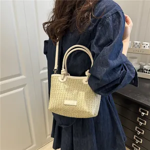 Straw woven handbag with white leather trim and adjustable strap for casual autumn style