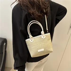 Elegant beige straw woven crossbody bag with white leather straps and knot detail