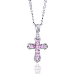 Macro shot of silver cross pendant with pink square crystal and white zircon stones