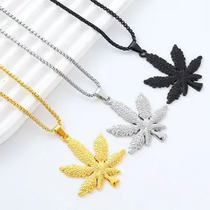 Maple leaf pendant necklaces in gold, silver and black finishes on a white tray