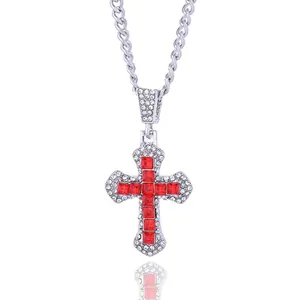 Detail of silver cross pendant with red square gems and sparkling white micro-diamonds