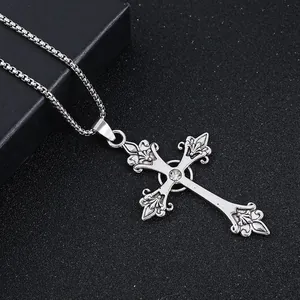 Gothic silver cross pendant necklace with clear center stone on a matte black background